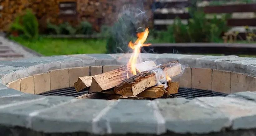 Round stone fire pit with a wood fire burning