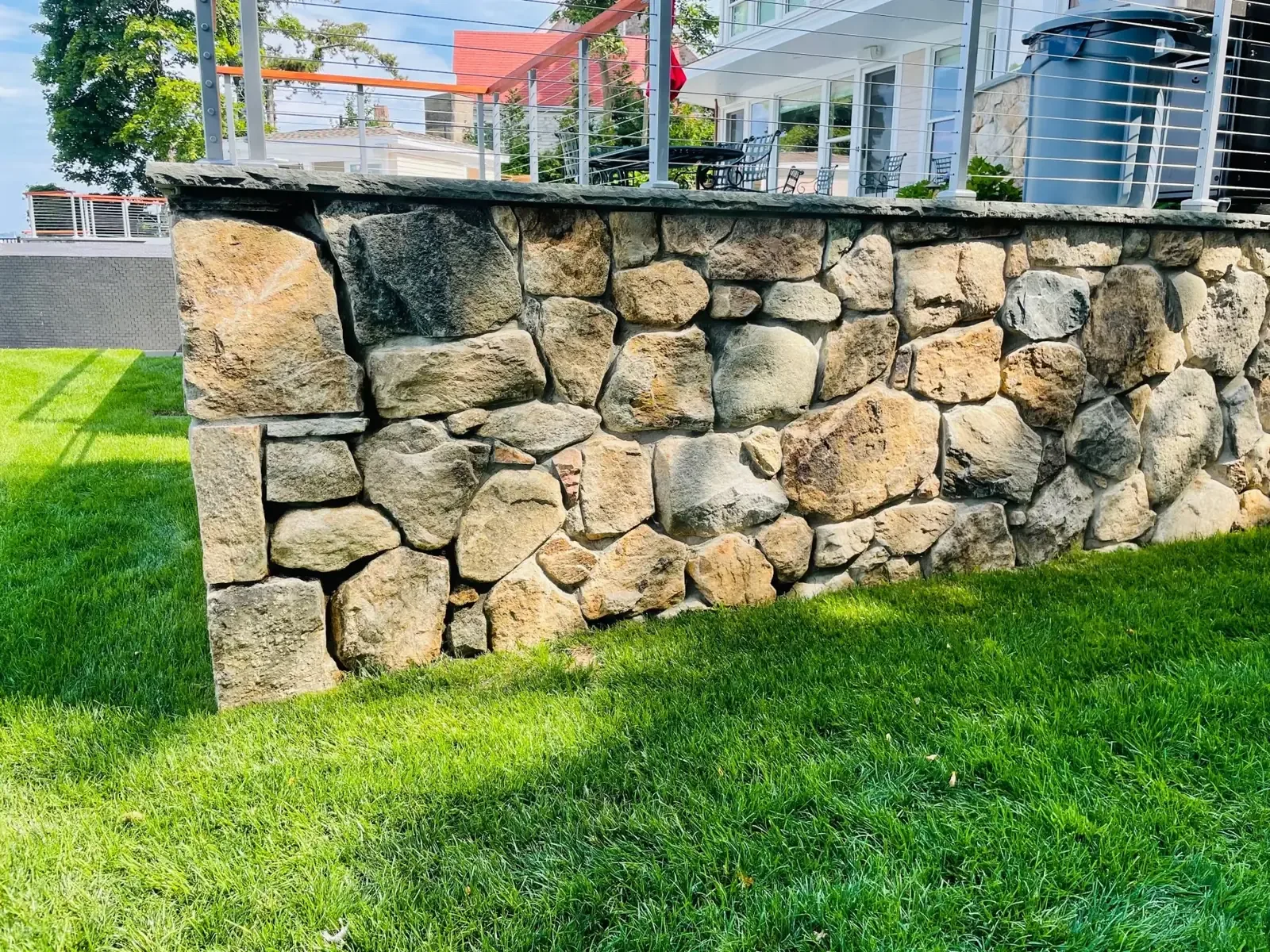 Fieldstone retaining wall above a lawn